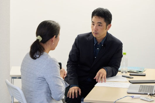 講師が受講者の話を真剣に聞いているセッション実演の様子